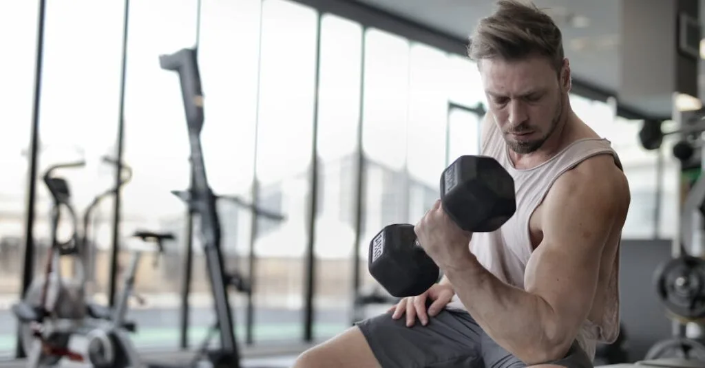 Focused man working out with a dumbbell in a well-equipped gym for strength training.